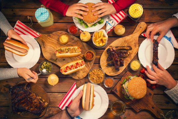 Young family celebrating 4th of July, they having traditional lunch at the picnic